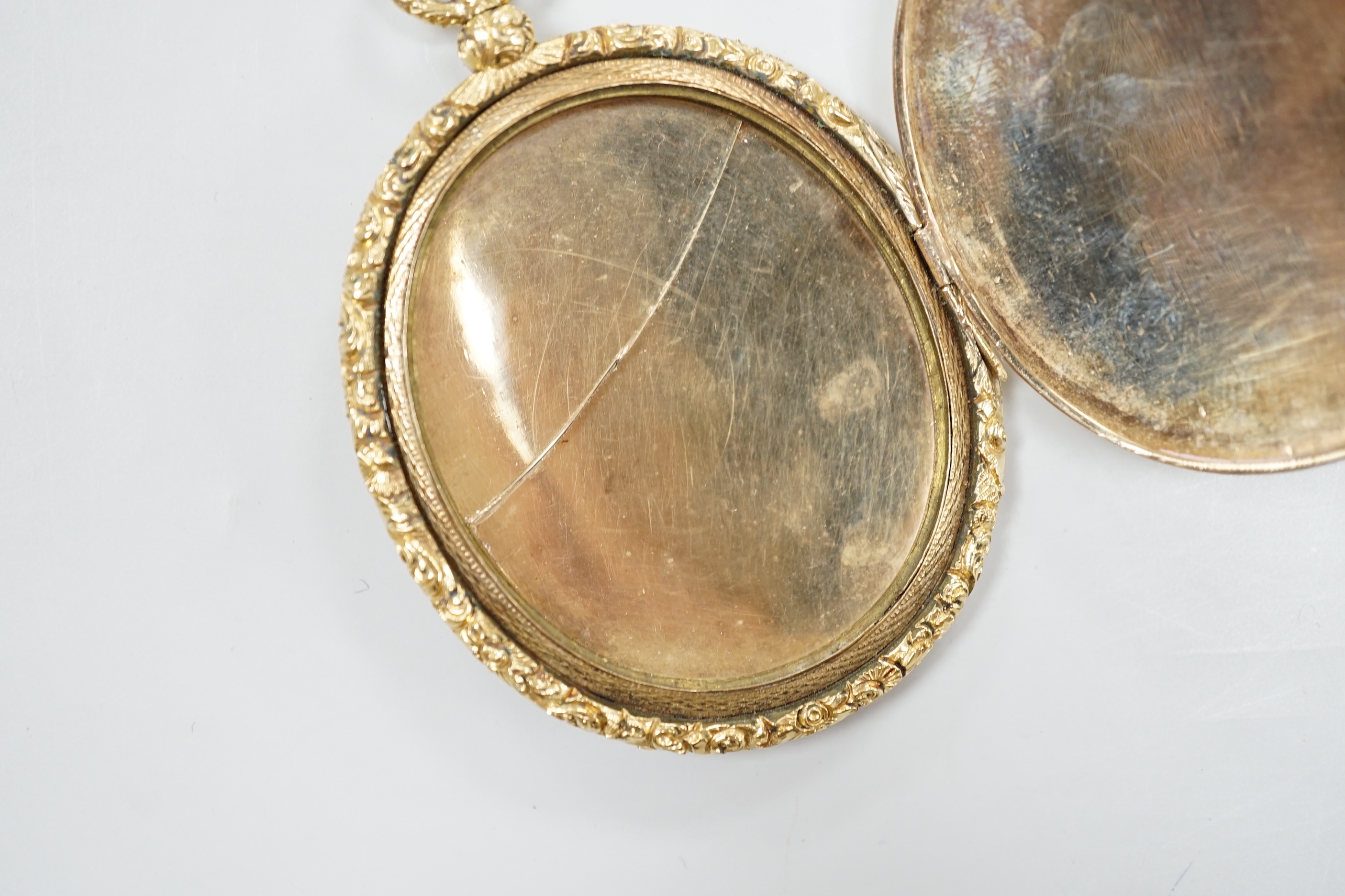 A Victorian engine turned yellow metal (tests as 9ct gold) oval pendant locket, housing a miniature on ivory depicting a lady, overall 7.75cm, gross 41 grams CITIES Submission reference, TVTSSFBX